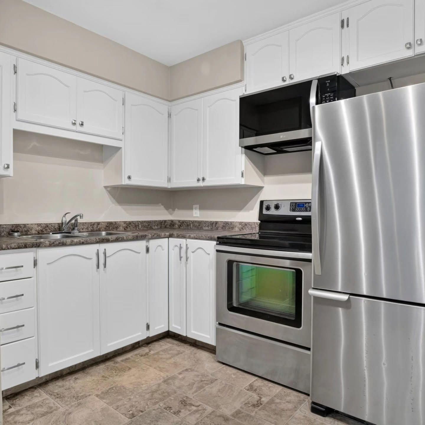 Refinished kitchen cabinets with a smooth sprayed finish in Calgary by Lady J's Painting