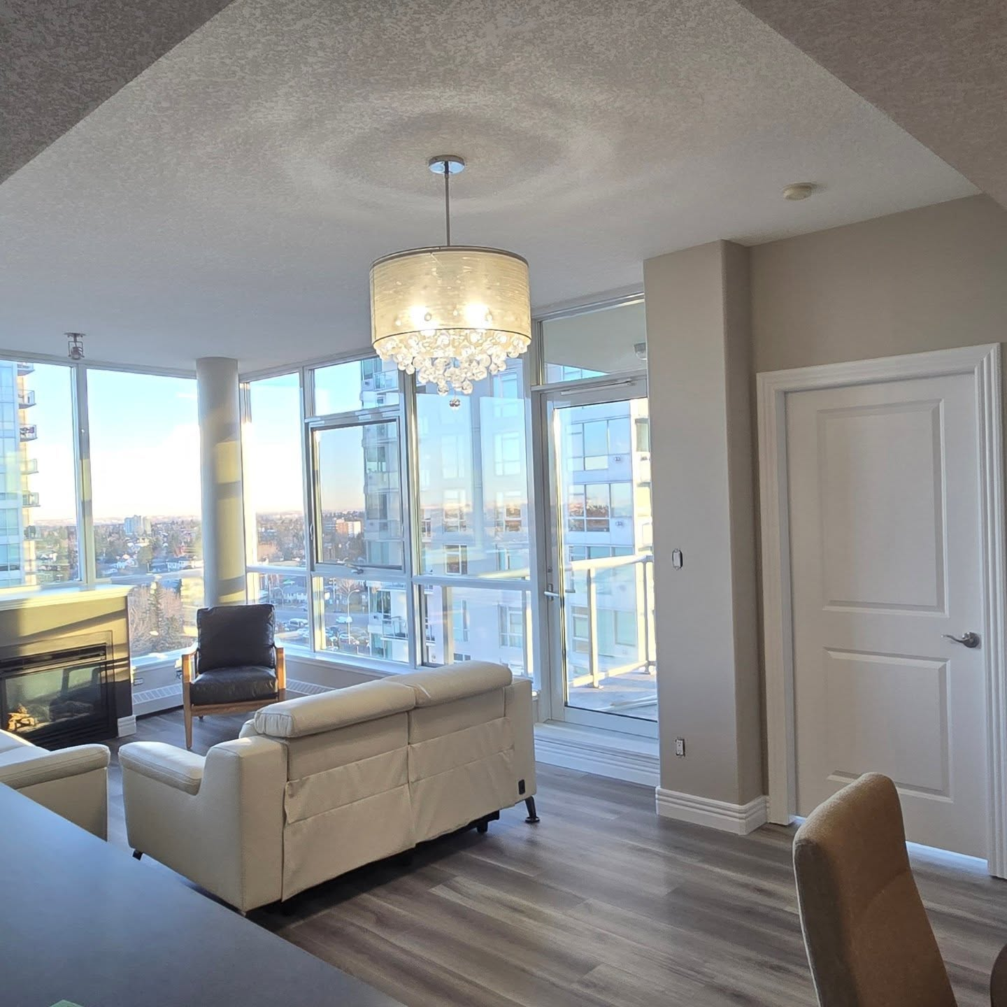 Bright modern Calgary living room with a deep forest green accent wall painted by Lady J's Painting & Decorating