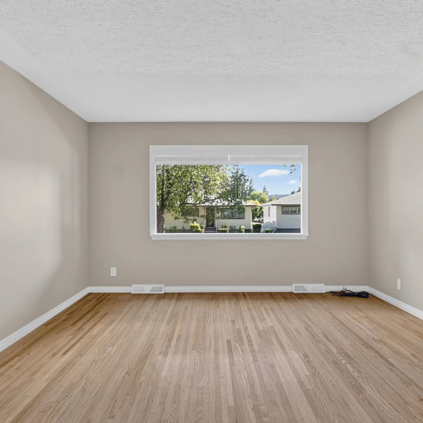 Freshly painted living room with large window in a Calgary home by Lady J's Painting